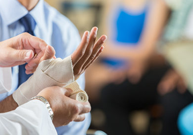 Patient having wrist bandaged by nurse in hospital