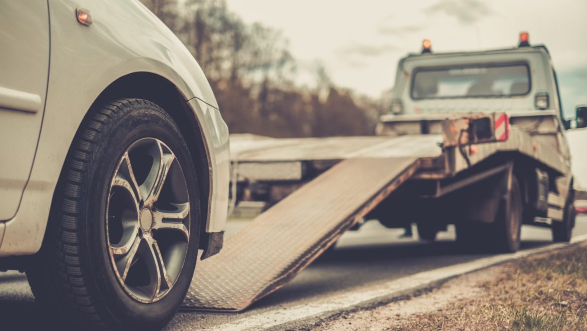 Loading broken car on a tow truck on a roadside